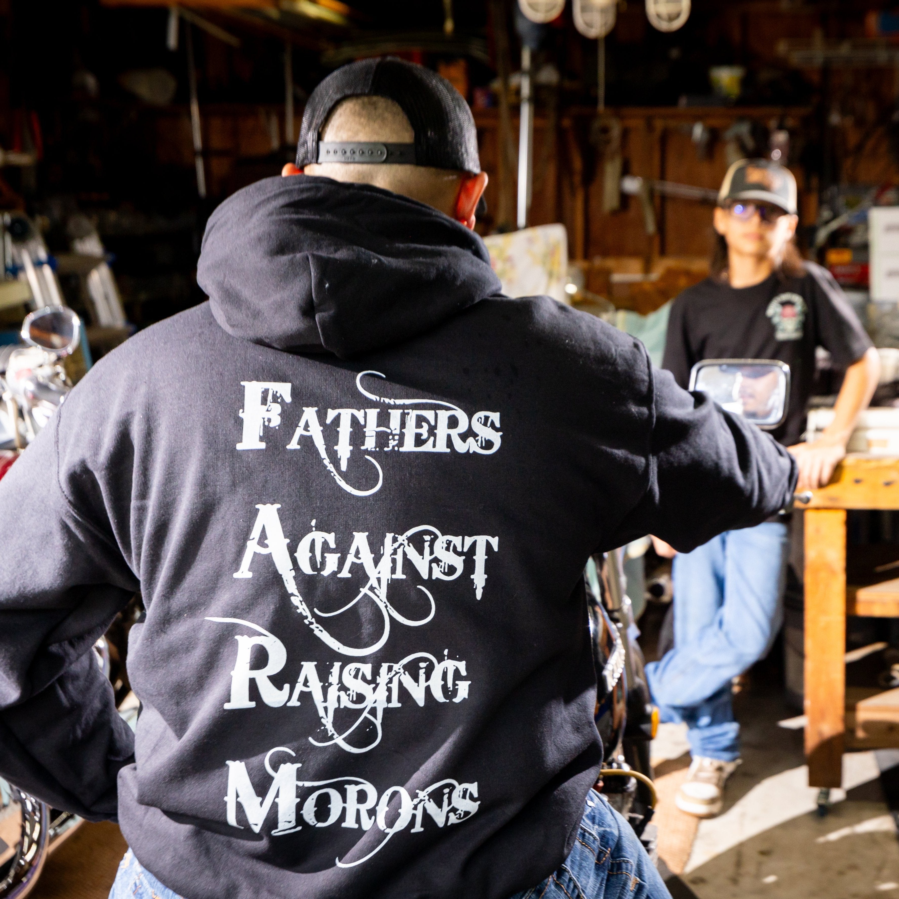 Back of the FARM  Hoodie with a kid watching dad get the bike ready for a ride